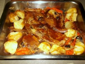 meat and vegetables in a metal pan on a table