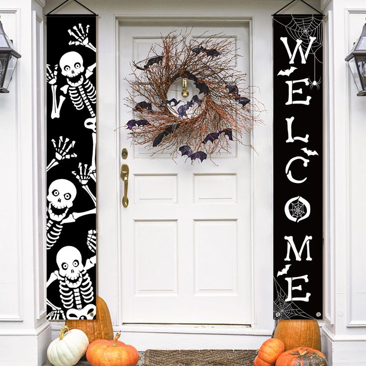 the front door is decorated for halloween with skeletons and pumpkins on it, along with a welcome sign