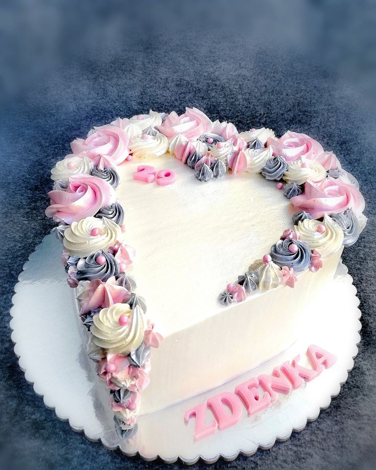 a heart shaped cake with pink and white frosting