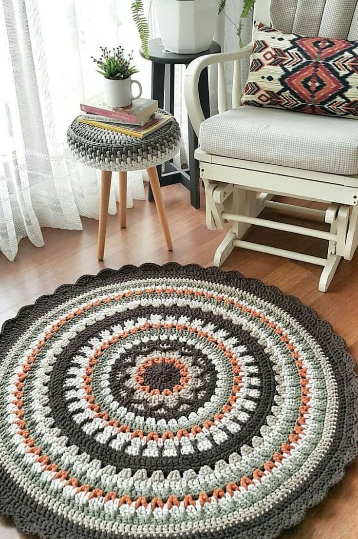 a crocheted rug is shown on the floor next to a chair and table