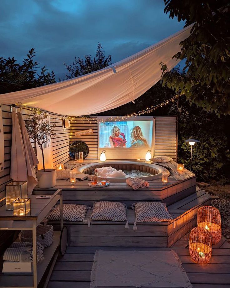 a hot tub sitting on top of a wooden deck next to a gazebo covered in lights