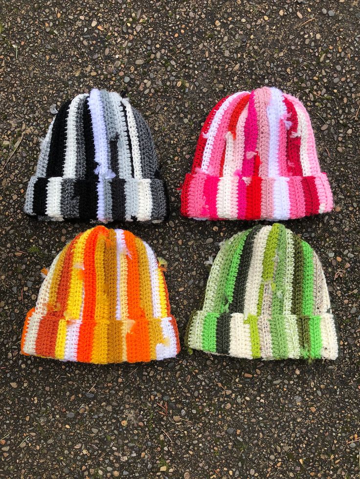 three knitted hats laying on the ground