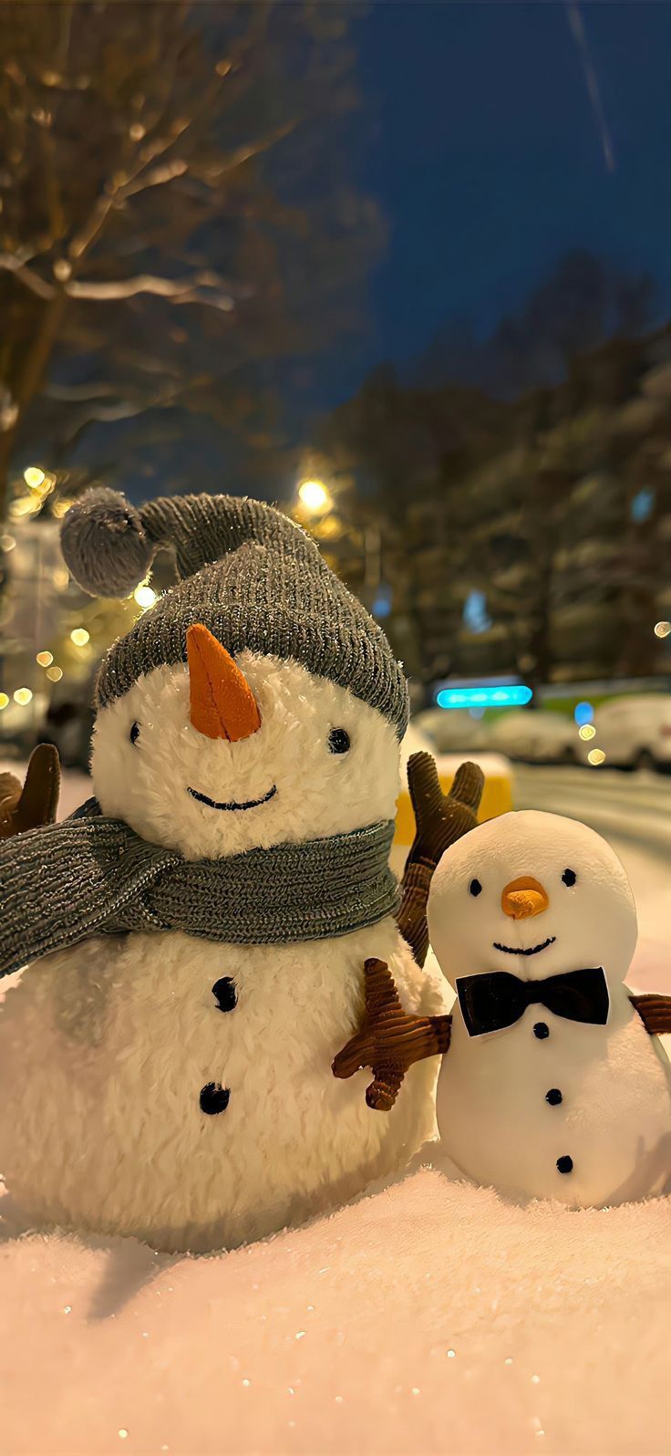 two snowmen are standing in the snow