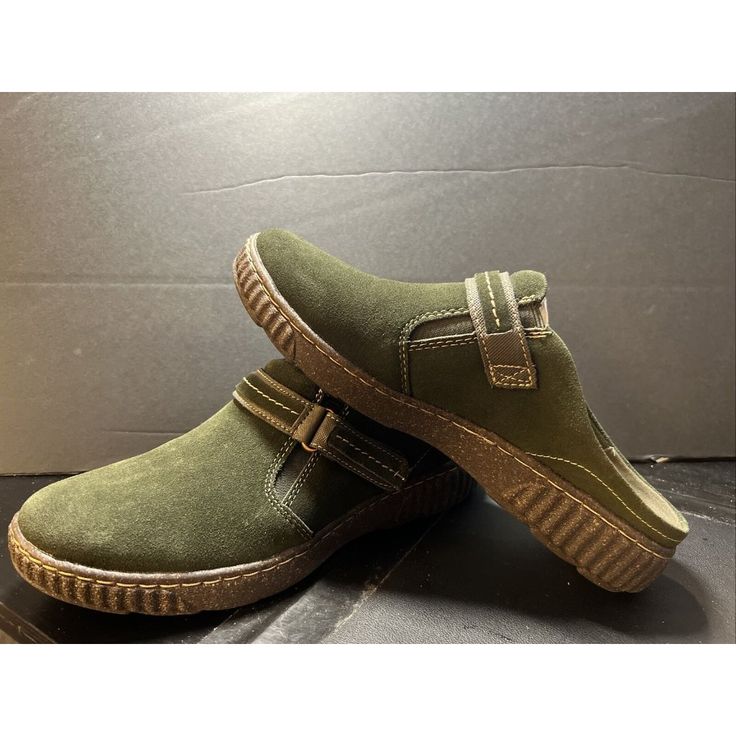 Elevate Your Travel And Casual Wardrobe With These Brand New Clarks Caroline May Clogs. These Closed-Toe Shoes In A Solid Olive Green Color Feature A Slip-On Design With An Adjustable Strap For A Comfortable Fit. The Low Heel Height And Rubber Outsole Make Them Perfect For Any Season, Whether It's Winter, Summer, Fall Or Spring. With Cushioned, Padded And Memory Foam Features, Your Feet Will Be Able To Withstand Long Walks Without Discomfort. The Embroidered Accents And Suede Upper Material Give Green Flat Heel Casual Clogs, Green Casual Clogs With Flat Heel, Casual Green Clogs With Flat Heel, Casual Green Closed Toe Slip-ons, Comfortable Green Mules With Cushioned Footbed, Green Casual Mules With Leather Footbed, Green Closed Toe Mules With Cushioned Footbed, Casual Green Slip-on Mules, Green Slip-on Mules With Removable Insole