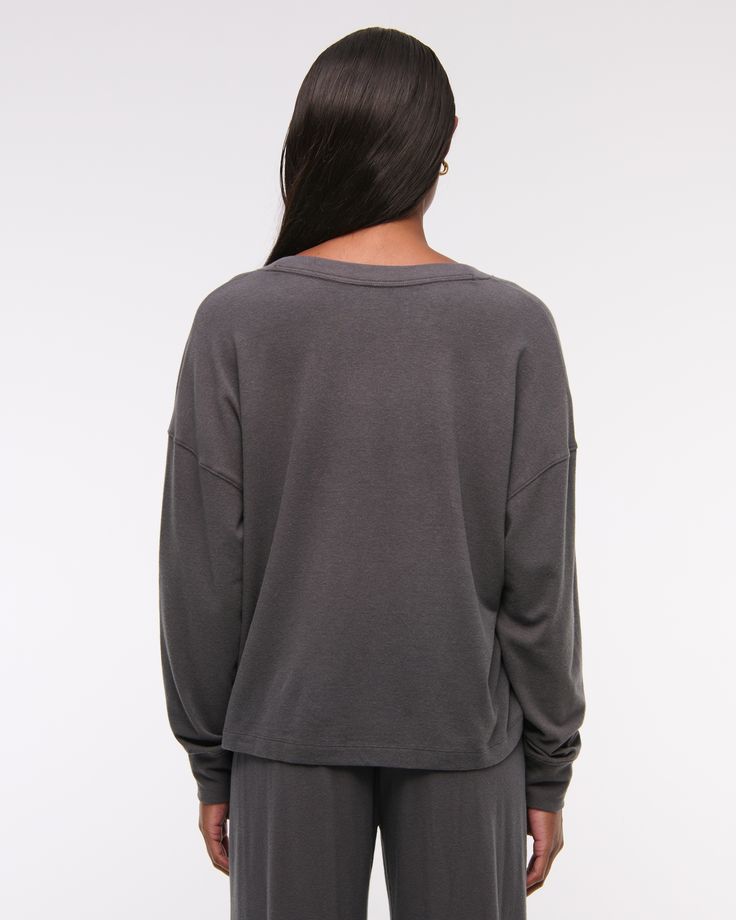 Slim-fitting long-sleeve henley top in our soft cozy lounge fabric and oversized-fit silhouette, featuring a button-up neckline and all-over textured detail. Comfortable Long Sleeve Soft Knit Tops, Comfortable Long Sleeve Sweater With Relaxed Fit, Versatile Sweatshirt With Ribbed Cuffs For Loungewear, Comfy Soft Knit Tops With Relaxed Fit, Winter Crew Neck Long Sleeve Loungewear Top, Super Soft Relaxed Fit Tops For Winter, Soft Knit Long Sleeve Tops For Lounging, Long Sleeve Soft Knit Tops For Lounging, Effortless Long Sleeve Tops For Fall