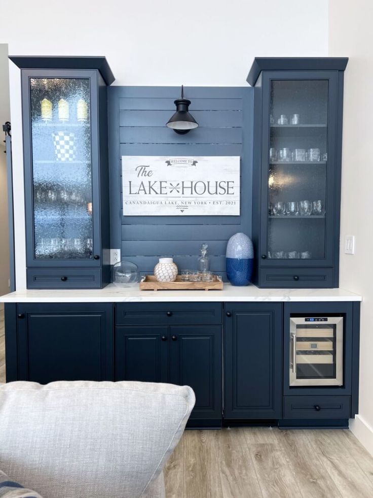 a kitchen with blue cabinets and white countertops in front of a sign that says the lake house