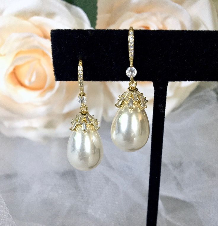 Best of both worlds! Iridescent pearls and clear cubic zirconia that capture the light from every angle with a perfectly translucent appeal come together to create a classy, sparkly and elegant pair of bridal earrings. The settings are gold / rhodium plated for a bright finish which enhances the intricate detailing and conveys a modern take on old elegance. Overall length of the earring is 1.5" (approx. 3.8cm). Width: 0.4" (approx. 1.2cm). Weight: 6g. Available in Yellow Gold and Silver with Whi White Pearl Bridal Earrings With Diamond Accents, Glamorous Pearl Drop Jewelry, White Crystal Pearl Earrings For Formal Occasions, Elegant Formal Crystal Pearl Earrings, Formal White Crystal Pearl Earrings, Formal Crystal Jewelry With Pearl Drop, Elegant Teardrop Crystal Earrings In Diamond White, Elegant Teardrop Diamond White Crystal Earrings, Formal Pearl Drop Crystal Jewelry