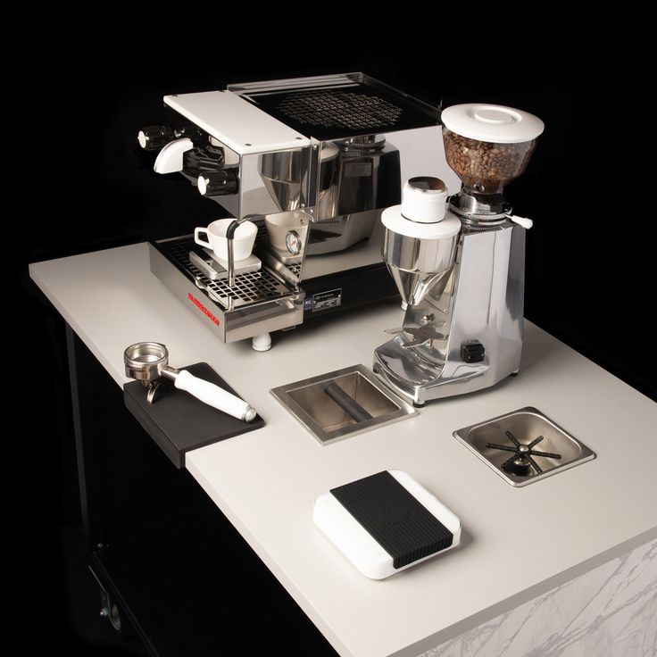 an espresso machine sitting on top of a counter next to other coffee accessories