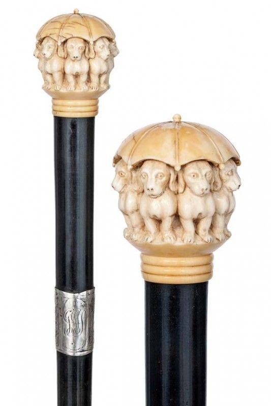 two carved ivory and black candlesticks, one with an umbrella top on it