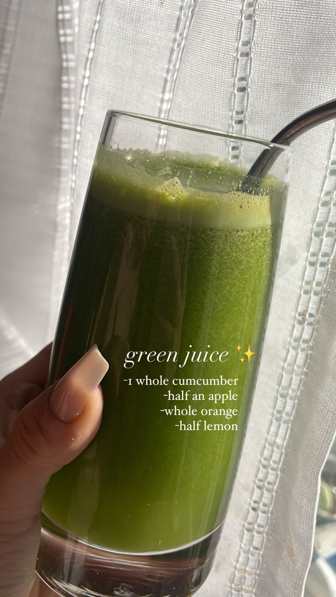 a person holding a green juice in a glass with the words green juice on it