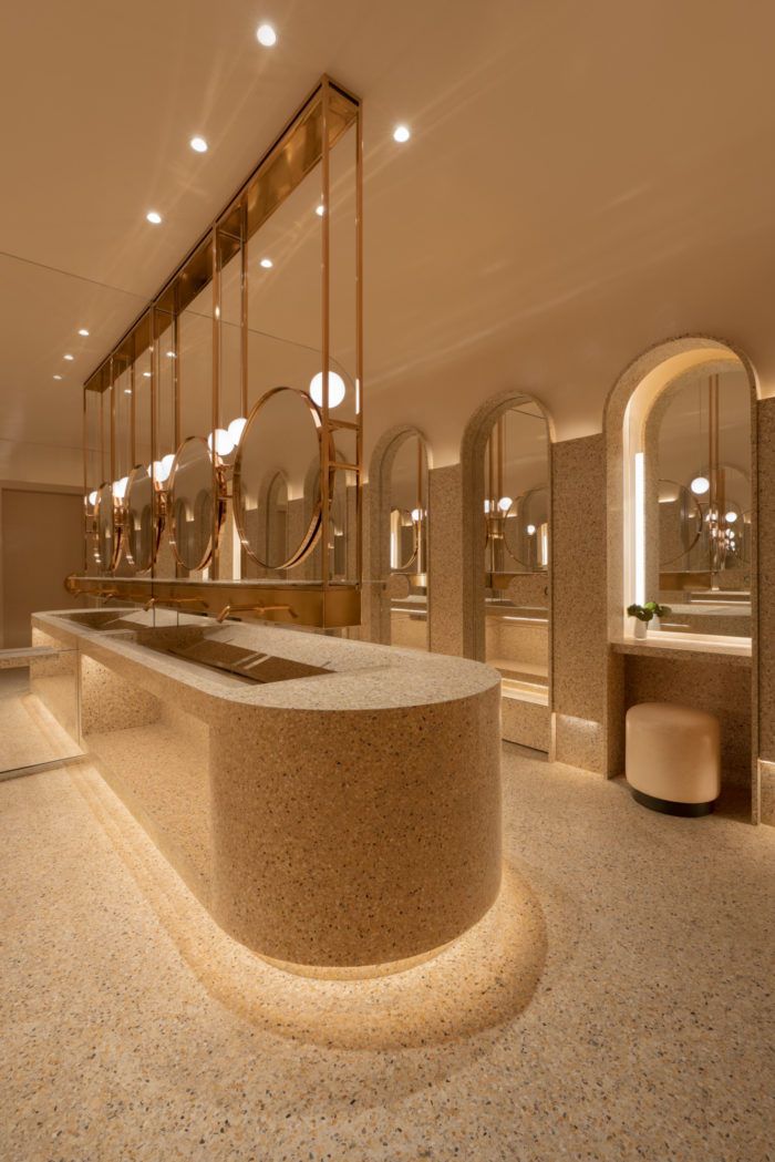 a fancy bathroom with sinks and mirrors on the wall, along with lights in the ceiling