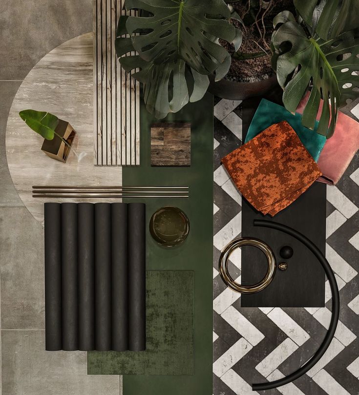 an overhead view of a table with black and white tiles, gold rings, green plants and other items