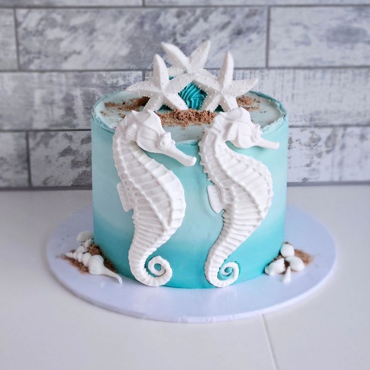 there is a blue cake with seahorses on it