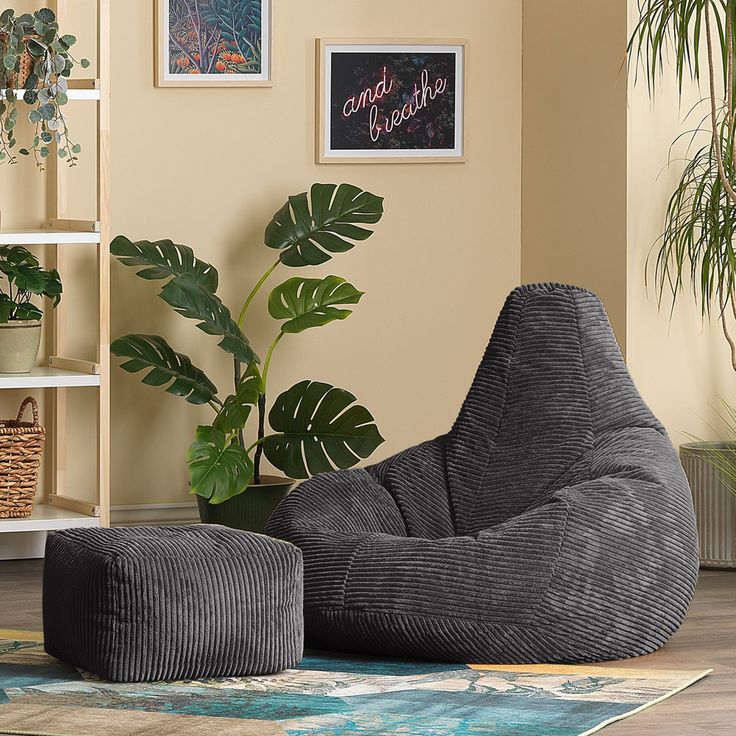 a yellow bean bag chair sitting on top of a rug next to a potted plant