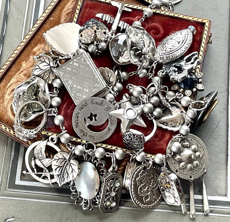 From a once loved, large collection of vintage jewelry, including necklaces, bracelets and earrings, I have gleaned all these silvery components to create a stunning assemblage necklace.    This is a fully loaded collection of interesting components that have a lovely weight and sound.  The silvery-gray pearlized glass bead chain is 18" long. I work with vintage and antique parts. Some may show some signs of wear or age. Please look at the pictures carefully, and contact me before purchasing if Antique Silver Sterling Jewelry With Vintage Charm, Handmade Silver Charm Necklaces In Costume Jewelry Style, Handmade Silver Charm Necklaces In Costume Style, Handmade Silver Charm Necklace In Costume Style, Handmade Silver Charm Costume Jewelry Necklace, Handmade Silver Charm Costume Necklace, Elegant Silver Vintage Charms, Victorian Vintage Charm Metal Jewelry, Silver Jewelry With Dangling Charms For Wedding