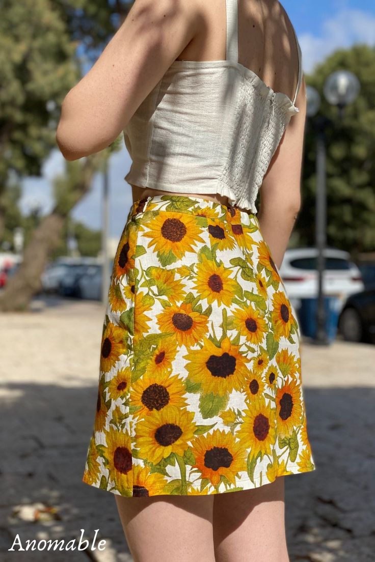 Your next favorite statement piece. Two subtle slits at the front add light detail to the summer mini skirt. A hand painted sunflowers print adorn the skirt. With warm yellow shades emanating bright, cheerful vibes, it's hard not to love this little number. The beautifully hand-painted sunflower print makes this a confidence-boosting style. The Rachel Skirt in Sunees creates a summery, colorful outfit full of vibrant energy. The floral mini skirt is made from 100% linen Floral Print Mini Skirt For Summer Beach, Summer Floral Print Mini Skirt For Day Out, Vacation Floral Print Mini Skirt, Summer Floral Print Mini Skirt For Vacation, Summer Mini Skirt With Floral Print For Vacation, Floral Print Mini Skirt For Summer Day Out, Summer Day Out Printed Skirt, Printed Summer Skirt For Day Out, Summer Floral Print Skirt