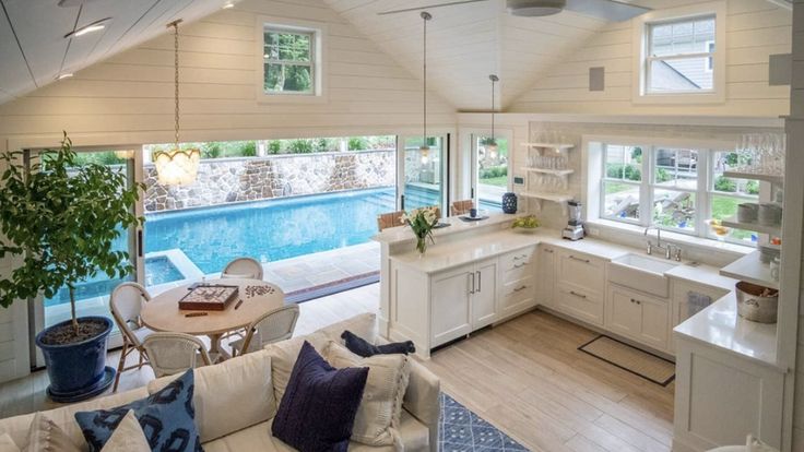 a living room filled with furniture and a swimming pool in the middle of an open floor plan