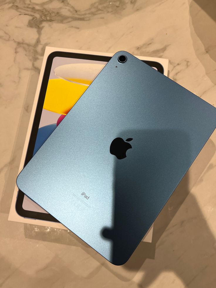 an apple ipad sitting on top of a table next to a card holder and box