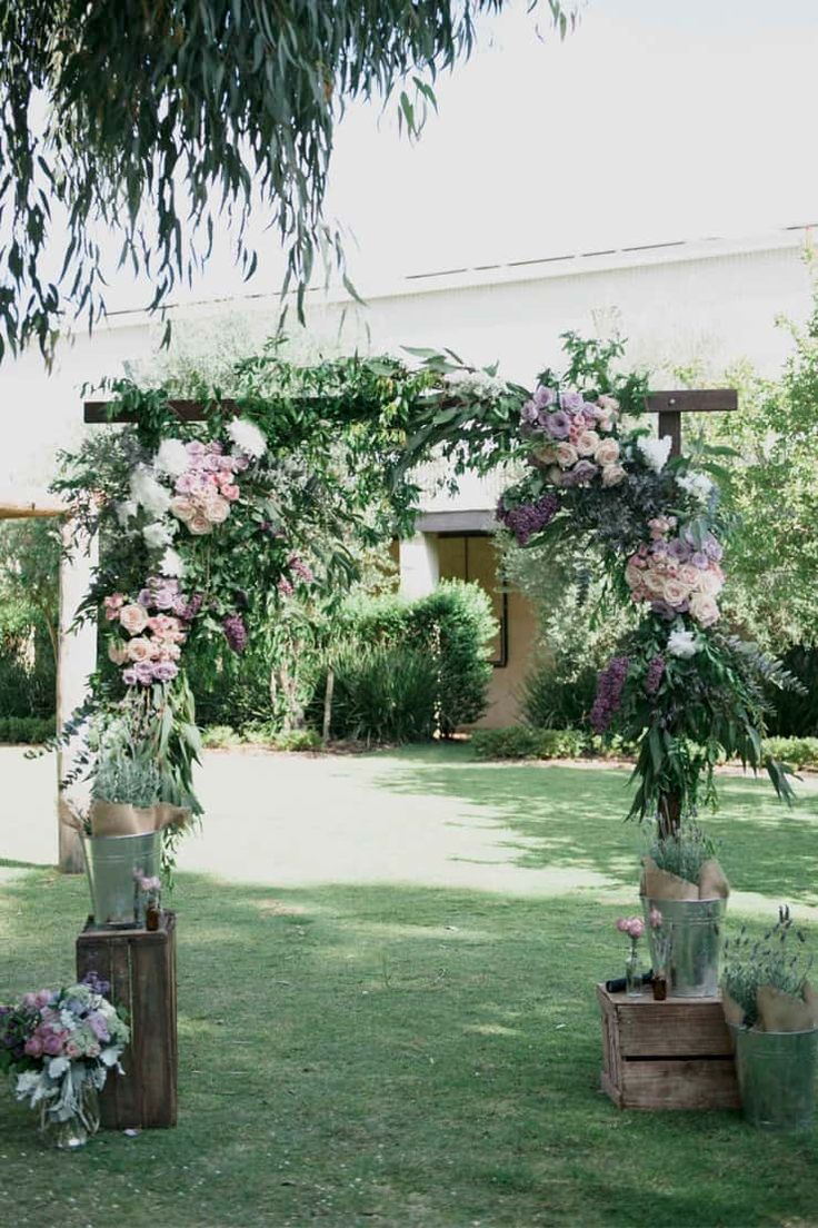 an outdoor ceremony setup with flowers and greenery