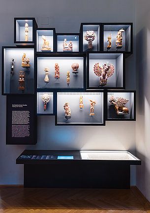 a display case filled with assorted figurines in glass cases next to a wooden floor