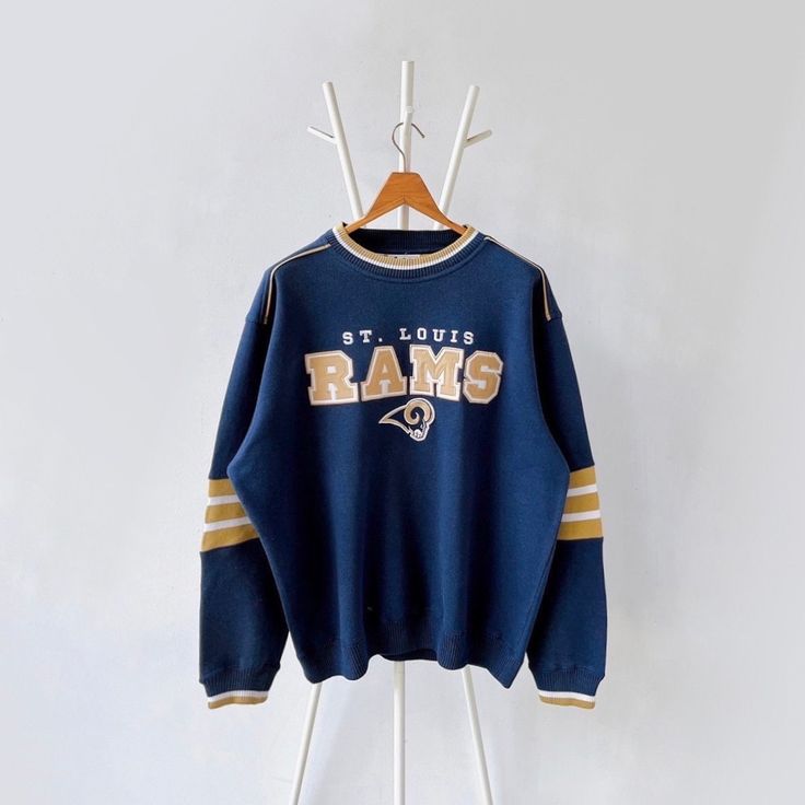 a sweatshirt hanging on a clothes rack with the word, st louis rams printed on it