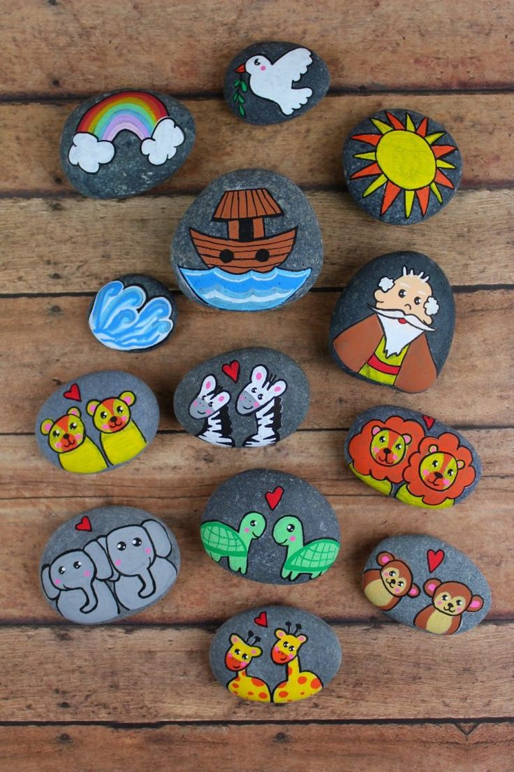 rocks with cartoon characters painted on them sitting on a wooden table next to each other