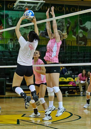 the volleyball players are trying to hit the ball