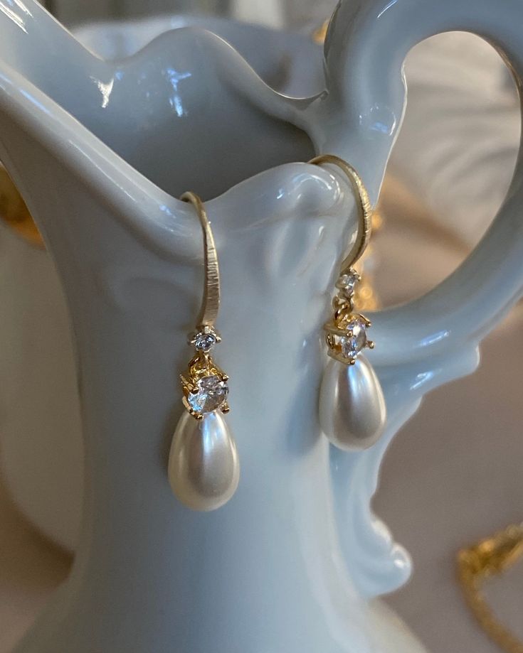 The French Pearl Drop earrings are a new favorite to the shop. Dreaming of weddings or an elegant sophisticated look, you are in luck! Luscious faux pearl drop with cubic zirconia and gold plated ear hook with cubic zirconia. White Diamond-accented Teardrop Earrings For Wedding, White Diamond Accent Teardrop Earrings For Wedding, White Diamond Accents Teardrop Earrings For Wedding, White Teardrop Wedding Earrings With Diamond Accents, Pearl Bridal Earrings With Diamond Accents For Wedding, Bridal Pearl Earrings With Diamond Accents For Wedding, Pear-shaped Teardrop Earrings With Diamond Accents For Wedding, Classic Pearl Embellished Bridal Earrings For Parties, Classic Pearl Bridal Earrings For Party