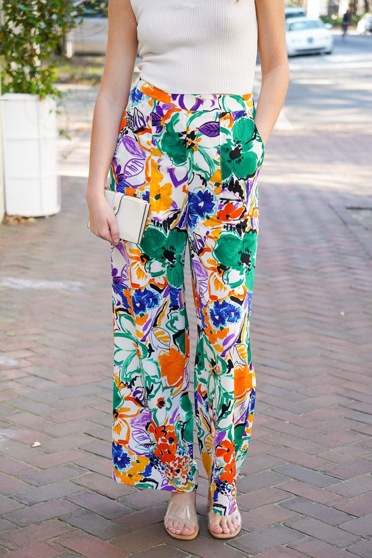 Get ready to light up the room with our Aurora Lights Pants! These high-waisted straight leg pants feature a vibrant and playful multi floral print in green, blue, purple, orange, and black hues. They feature an elastic waist at the back and square pockets that add comfort and functionality, making them the perfect addition to your spring and summer wardrobe. Pair with our Bristol Collared Tank to complete the look. They are lightweight, non-sheer, and fit true to size. 100% Polyester Brand- Ent Trendy Colorful Bottoms For Spring, Trendy Colorful Pants For Spring, Trendy Colorful Spring Pants, Trendy Colorful Spring Bottoms, Colorful Long Pants For Spring, Colorful High-waist Bottoms For Spring, Colorful Wide Leg Bottoms For Spring, Multicolor Wide Leg Pants With Floral Print, High Waist Colorful Bottoms For Spring