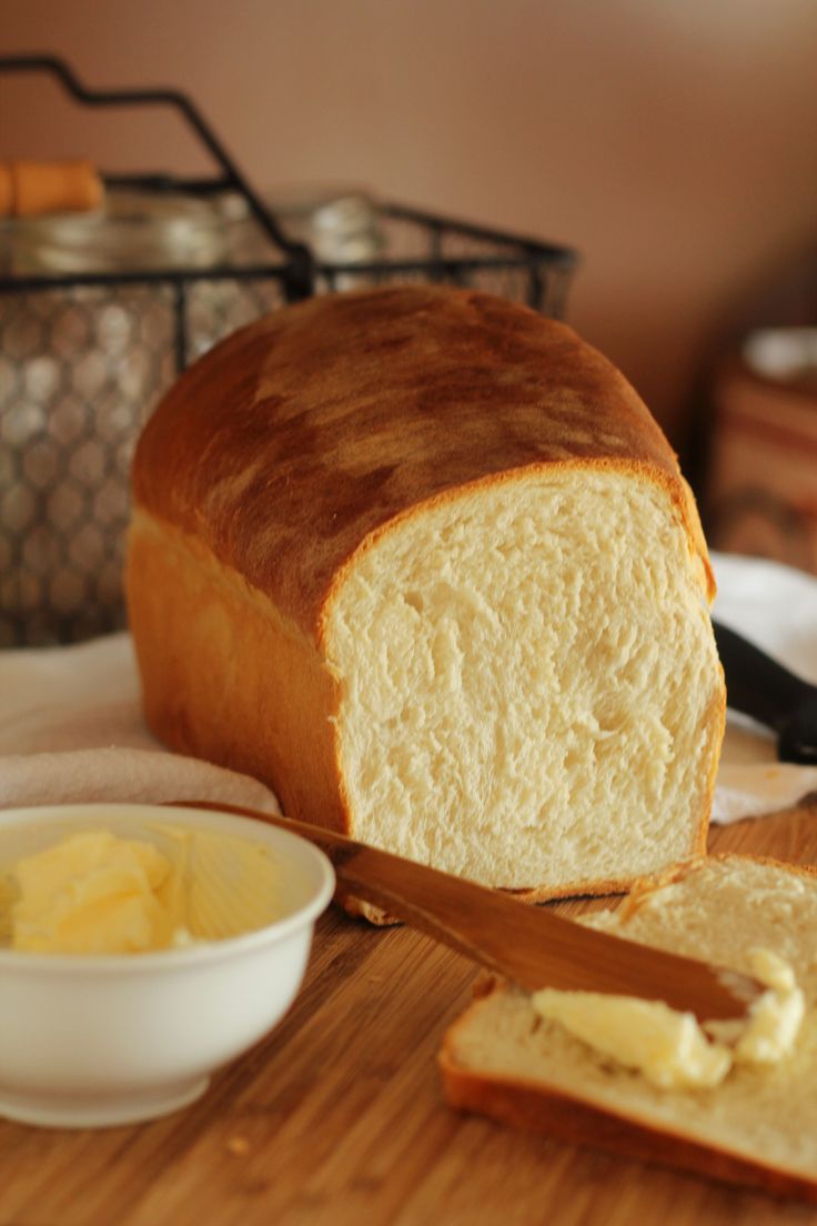 a loaf of bread sitting on top of a cutting board next to butter and a knife