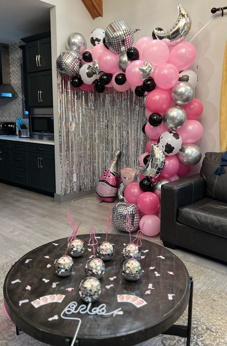 a living room filled with balloons and confetti on top of a coffee table