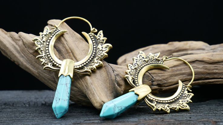 Beautiful, cleanly crafted earrings made of brass and turquoise. Material: brass, turquoise Ear hole size: 1mm Dimensions approx: 42 x 62 mm Quantity: 1 pair Gold Bohemian Earrings With Patina, Bohemian Gold Earrings With Patina, Festival Brass Cartilage Earrings, Handmade Turquoise Brass Earrings, Blue Brass Earrings For Festival, Blue Brass Earrings For Festivals, Turquoise Brass Spiritual Jewelry, Adjustable Brass Plug Earrings For Festival, Turquoise Dangle Brass Earrings