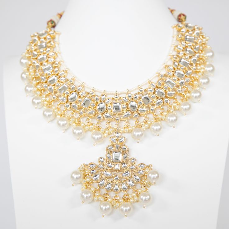 The Amaya Jewelry Set will add elegance to your look. With High-Quality Kundan, this piece is perfect to turn heads this festive season. Specifications Materials used: kundan, pearls, gold plating At Romikas, we pride ourselves on the craftsmanship and high quality of our jewelry, designed to enhance your natural beauty. Please contact us with any questions. Kundan Necklace Set, White Gold Chain, Kundan Necklace, White Gold Chains, Kundan Necklaces, Festive Season, Matching Earrings, Gold Plating, Festival Season