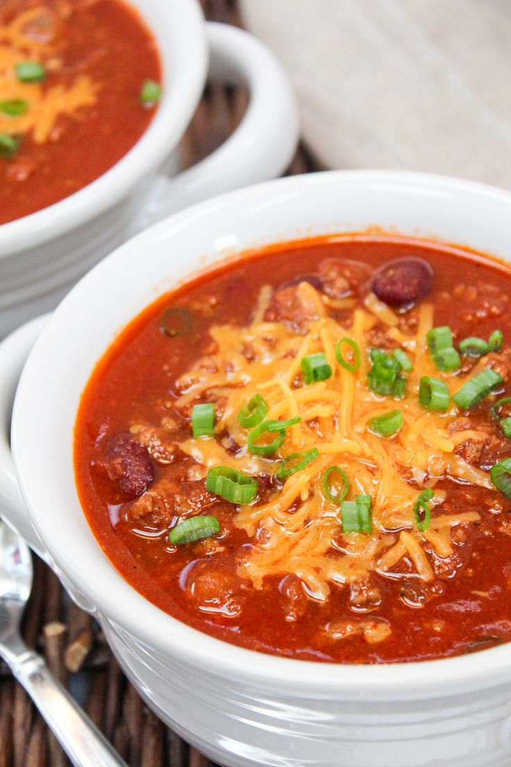 a white bowl filled with chili and cheese