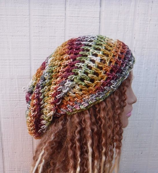 a woman with long curly hair wearing a multicolored crochet beanie