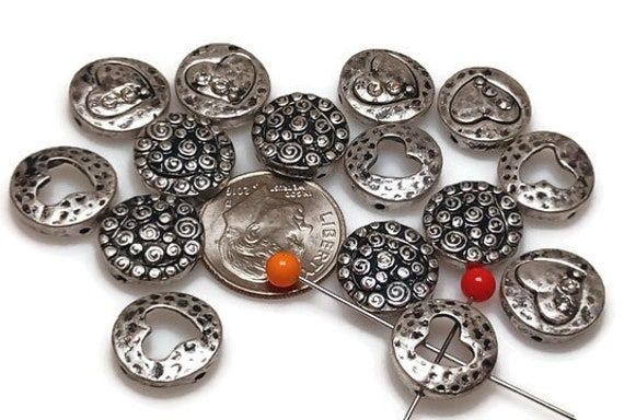 2-hole slider beads size 12 wide and 12 mm tall, and the holes are 9 mm apart. Cast in antique silver, this mixed package contains everything in the image.  Some with amazing texture, some with a heart shape and more. Package as shown in the image. All beads and clasps in our shop are lead and nickel-compliant.  15 beads per package Slider beads are super fun and easy ways to dress up your jewelry designs.  I have seen people utilize these in a variety of ways, from using one as a focal bead to Heart Shaped Beads For Crafting, Heart-shaped Beads For Crafting, Silver Heart Beads, Silver Heart Shaped Beads, Silver Heart-shaped Beads, Flat Beads, Beaded Flats, Jewelry Making Bracelet, Jewelry Clasps