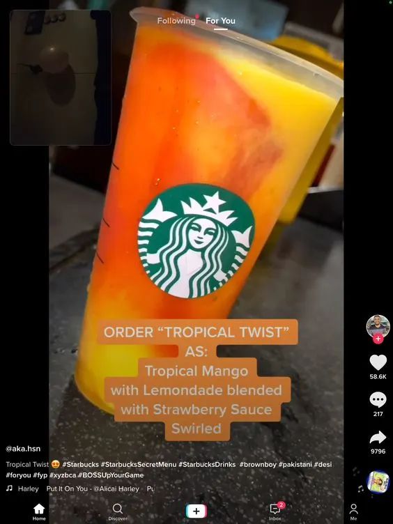 an orange drink with strawberries in it and the caption order tropical twist as