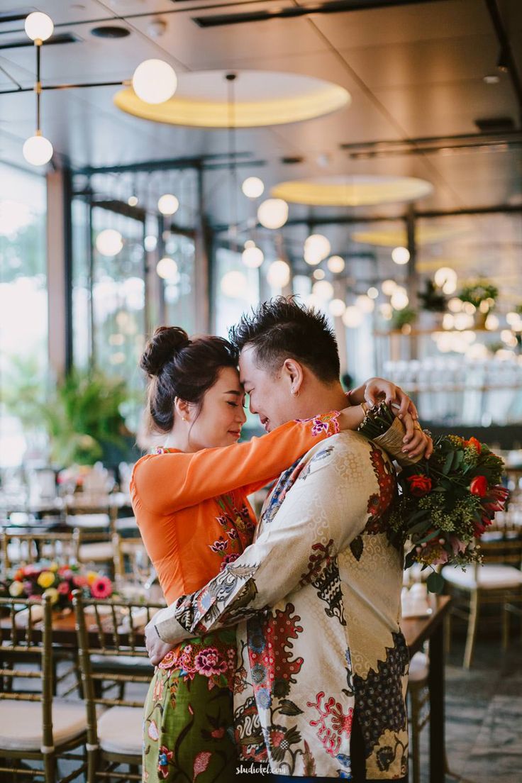 two people hugging each other in front of tables