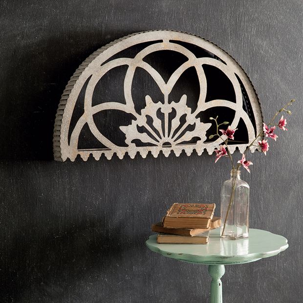 a table with a vase and book on it next to a wall mounted shelf in the corner