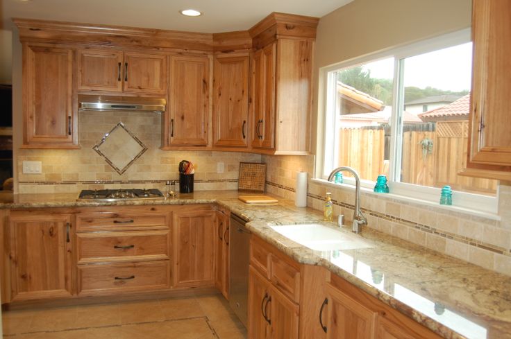 a kitchen with wooden cabinets and marble counter tops