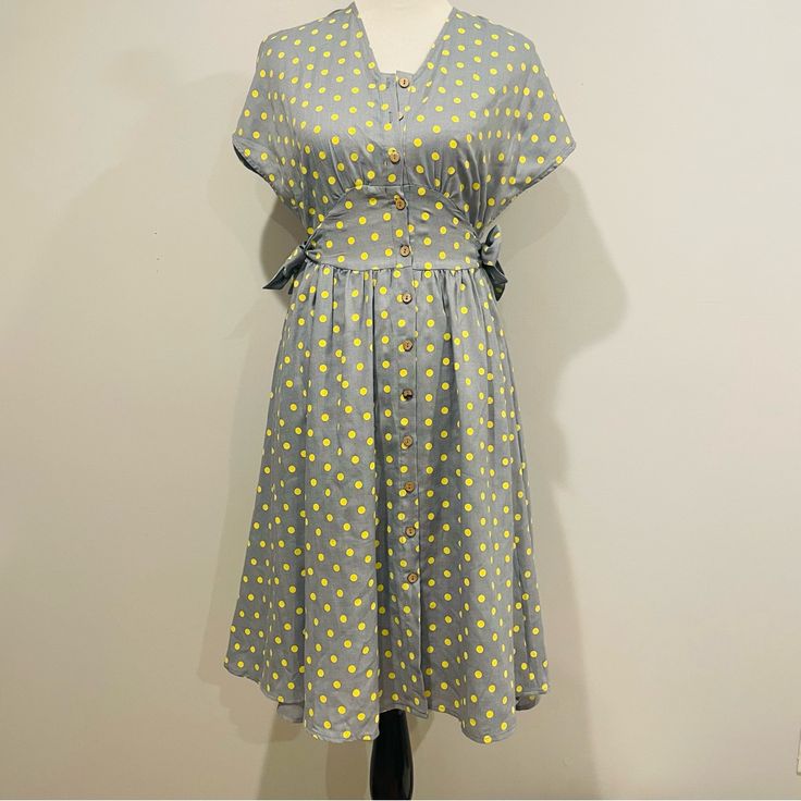 Easel Vintage Blue Polka Dot Dress Size Small. 65% Polyester 35% Rayon, V Neck Neckline, Wide Arm Opening, Front Wood Button Closure, Two Side Waist Tie Detail, Round Hem. Vintage Polka Dot Dress With Short Sleeves For Summer, Retro Polka Dot Dress For Daywear, Retro Polka Dot Day Dresses, Knee-length Yellow Vintage Summer Dress, Knee-length Yellow Vintage Dress For Summer, Yellow Knee-length Vintage Summer Dress, Yellow Knee-length Vintage Dress For Summer, Yellow Short Sleeve Vintage Dress For Spring, Yellow Vintage Short Sleeve Dress For Spring