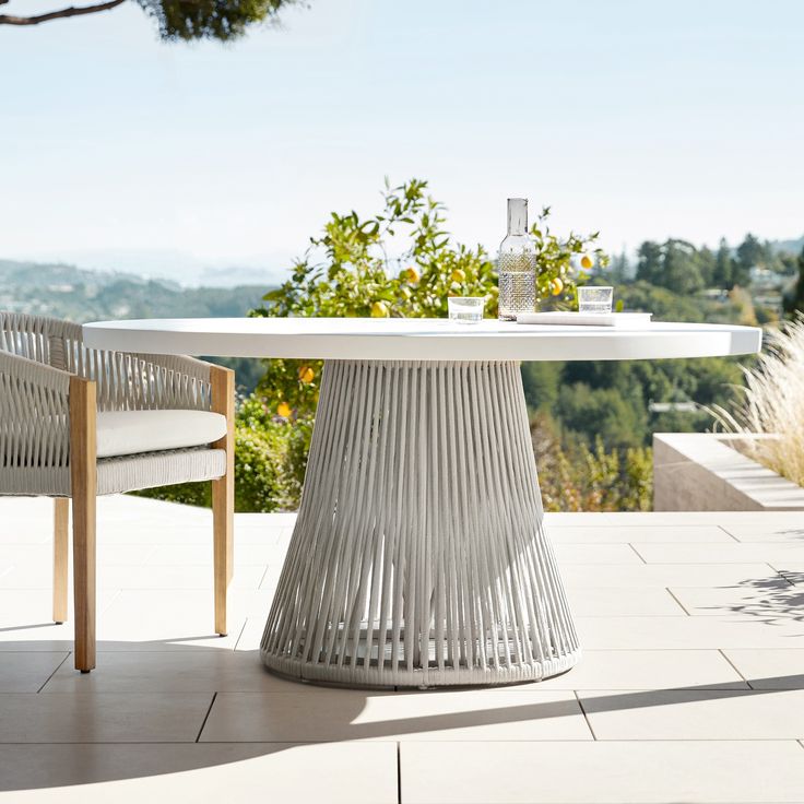 a table and chairs on a patio with trees in the background