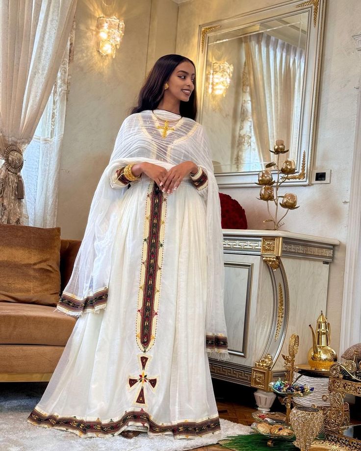 Embrace the timeless style of Ethiopian tradition with our collection of simple yet sophisticated Habesha kemis. These versatile garments are designed with a modern aesthetic, featuring clean lines and darker hues that exude elegance and sophistication. Whether you're attending a special occasion or simply want to add a touch of Ethiopian flair to your everyday wardrobe, our kemis offer a perfect blend of tradition and contemporary style. Crafted from high-quality fabrics and adorned with subtle White Formal Dress With Traditional Drape, Formal White Dabka Dresses, Elegant Fitted Kurta For Traditional Ceremonies, Elegant Maxi Length Kurta For Traditional Ceremonies, Elegant Maxi Sets For Traditional Ceremonies, Elegant Fitted Kaftan For Ceremonial Occasions, Elegant Long Kurta For Traditional Ceremonies, Habesha Dress, Ethiopian Traditional Dress