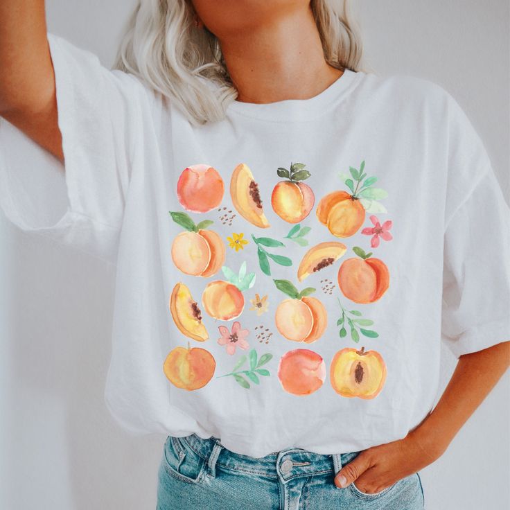 botanical shirt | fairycore apparel | fairycore shirt | fruit drawing tshirt | fresh peaches shirt | cottage core shirt | summer peach shirt This Bella T-shirt is light-weight with just the right amount of stretch. Perfect for wearing on its own or layering with a jacket or cardigan - this Tee is comfortable, soft, and durable. * 100% combed and ring-spun cotton * Fabric weight: 4.2 oz (142 g/m2) * Pre-shrunk fabric * Side-seamed construction * Shoulder-to-shoulder taping * We do not accept returns or exchanges. However, if you experience an issue with them item received, please message the shop Woah there! It looks like you've gone a little too far - don't like this tshirt? No problem, we won't take it personally 😉 You can check out some of our other great designs back at our shop here: Peach Themed Outfit, Summer Cottagecore Shirt With Relaxed Fit, Cottagecore Relaxed Fit Summer Shirt, Summer Cottagecore Relaxed Fit Shirt, Casual Peach Summer Shirt, Peach Short Sleeve Shirt For Summer, Relaxed Fit Cottagecore Summer Shirt, Summer Peach Cotton Shirt, Peach Cotton Summer Shirt