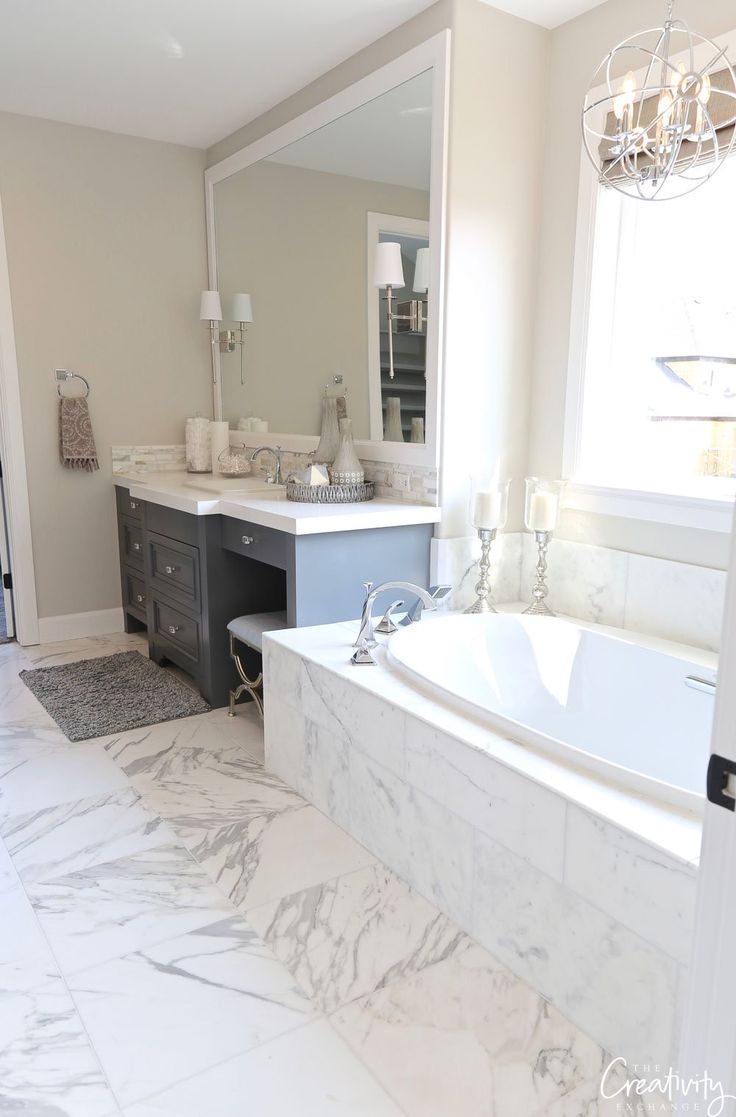 a bathroom with marble flooring and white walls, along with a large bathtub