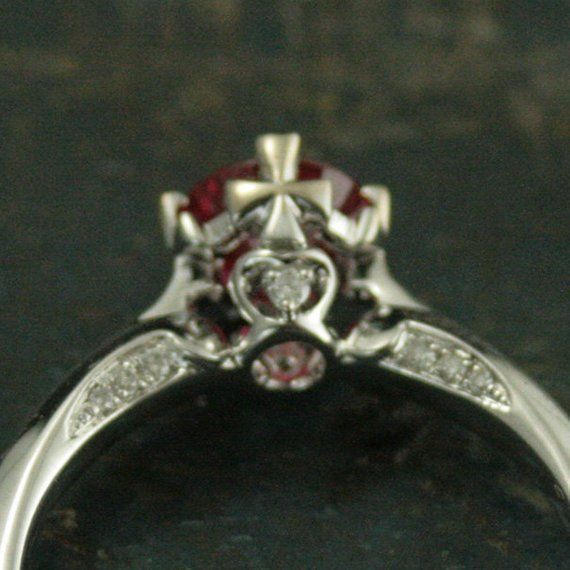 Ruby~July's Birthstone. It represents love, health and wisdom. And on this very special one of a kind ring it is paired with diamond accents and the cross. Faith, love, health and wisdom all in one! Small pave diamonds line the inner edges of the shank leading to the center where a heart and cross motif sport yet another small diamond. The cross, itself, forms each of the four prongs holding the center 6mm Chatham lab grown flawless ruby in place.Deb is a professional jeweler that has dedicated Symbolic Diamond Accented Rings For Anniversary, Symbolic Diamond Wedding Ring, Spiritual Diamond Promise Ring, Symbolic Diamond Rings With Diamond Accents, Diamond Ruby Ring With Center Stone For Promise, White Gold Ruby Ring With Center Stone For Promise, Heirloom Ruby Promise Ring With Round Cut, Heirloom Ruby Ring With Diamond For Promise, Heirloom Diamond Ruby Promise Ring