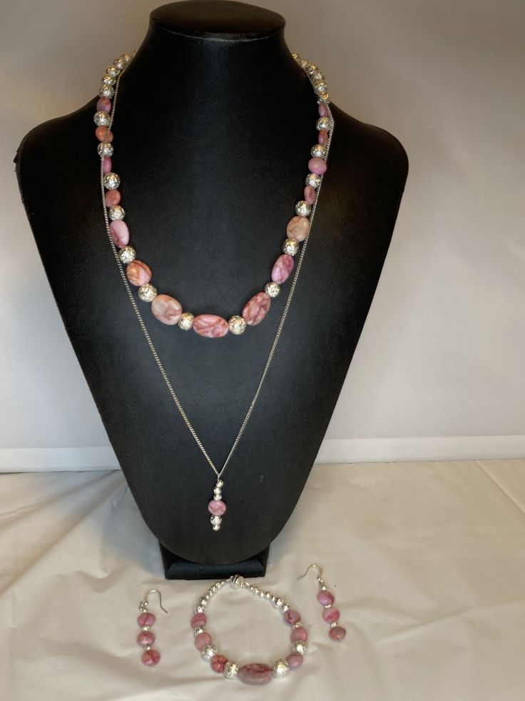 Gorgeous four piece set made of pink matrix jasper and silver lava stone. Necklace is 20 inches long with a magnetic clasp. Bracelet is 7-1/2 inches with a magnetic clasp. The earrings are 1-1/2 inches. The fourth piece drop pendant is 24 inches long. Suitable for any occasion. Adjustable Double Strand Pink Jewelry, Adjustable Handmade Pink Jewelry Sets, Silver Jewelry With Natural Stones And Rhodonite, Silver Rhodonite Jewelry With Natural Stones, Lava Stone Necklace, Jasper Jewelry, Clasp Bracelet, Earring Holder, Christmas Earrings