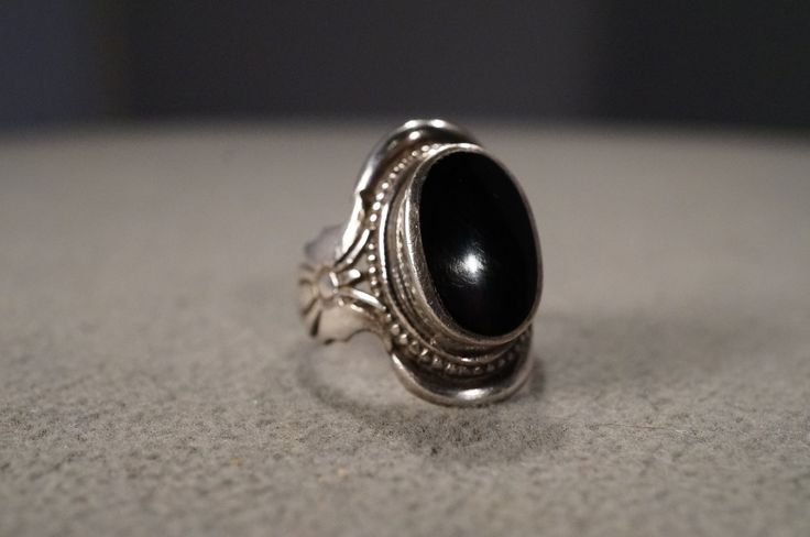 I am offering you this vintage sterling silver, art deco style wedding band stacker ring. This features a gorgeous bezel set oval shaped, genuine black onyx stone. This stone is set in a fabulous single stone setting. It measures app. 1 inch.  It has color saturation and intensity that is endless, as seen in the provided pictures. What an eye catcher! It has the classic highly desired solid setting that is very thick and substantial, giving this ring allure and extra interest. This ring is currently a size 6.5, however it could be sized up or down very easily. It weighs app. 7 grams.   Please review all of my pictures, as they are all a very important part of my listing / description.  This unique vintage ring is a must have for the ring collector. Buyer pays all shipping and handling fees Vintage Onyx Ring Bohemian, Black Oval Jewelry With Bezel Setting, Vintage Black Oval Cabochon Ring, Classic Adjustable Jewelry With Oval Cabochon, Vintage Jewelry With Bezel Setting In Round Band, Vintage Black Oval Cabochon Jewelry, Art Deco Oval Jewelry With Polished Finish, Adjustable Classic Jewelry With Oval Cabochon, Classic Oval Cabochon Sterling Silver Jewelry