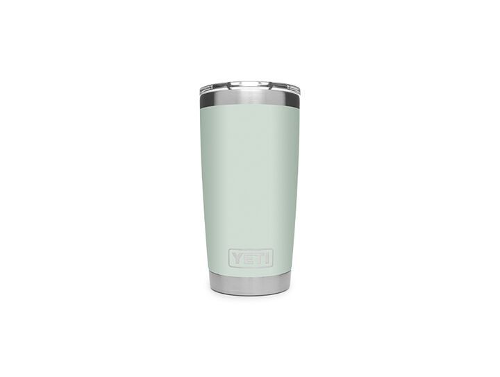 the yeti tumbler is light green and has a stainless steel trim on it