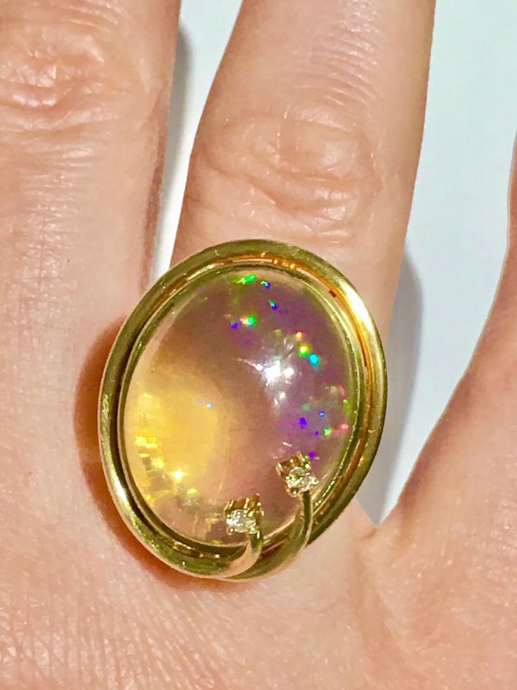 Fantastic Large Crystal Ethiopian Opal crafted in solid 14k yellow gold with Diamonds Ring. Looks very much like Mexican contra Luz opal. Also Reminds of antique Pools Of Light cabochon but with lots of fire inside of it! Like a real Celestial creation! Please see photos. The size of the opal is large and it is high dome - approx size of the opal 21x16x8 mm! Approx 15-17Ct ! Diamonds approx 1.8mm each! It is translucent crystal opal and Full of colorful fire colors - see photos please - the play Elegant Gold Opal Cabochon Ring, Gold Ethiopian Opal Heirloom Rings, Gold Ethiopian Opal Ring Hallmarked, Heirloom Gold Opal Cabochon Ring, Heirloom Gold Opal Ring With Cabochon, Heirloom Ethiopian Opal Gold Rings, Gold Moonstone Cabochon Ring, Gold Opal Birthstone Ring, Luxury Gold Multi-stone Opal Ring